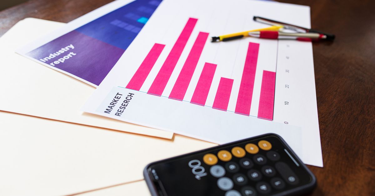Illustrative market research chart and calculator on wooden desk for business analysis.